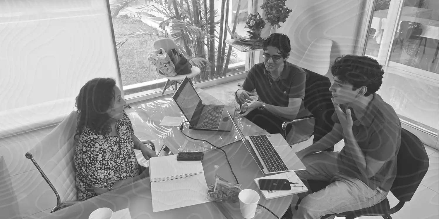 Equipo de Psicmund reunido trabajando en una mesa con laptops y cuadernos.